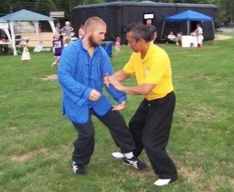 Dr. Micah Naziri training Chinese martial arts outdoors with a teacher