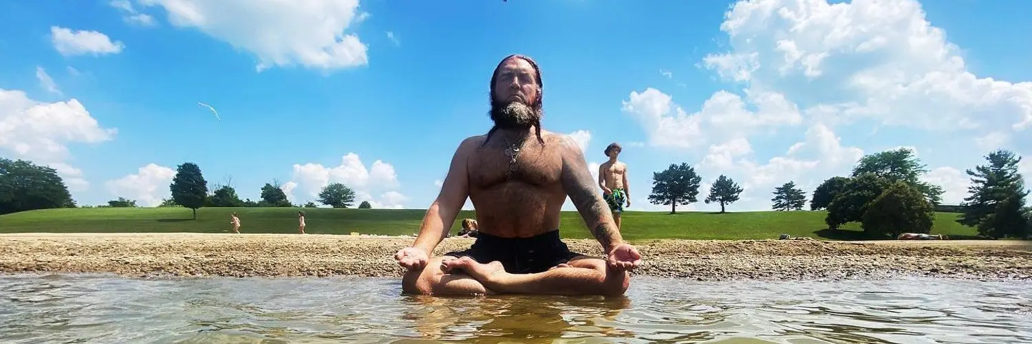 Dr. Micah Naziri meditating at the water's edge